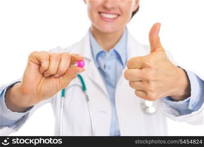 Closeup on pill in hand of smiling doctor woman