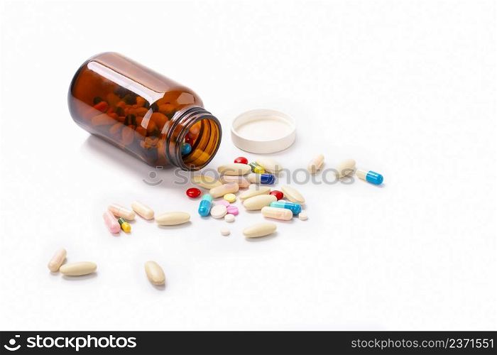 Closeup on pills capsules spilling out of pill bottle isolated on a background , Healthcare and medical drugs concept