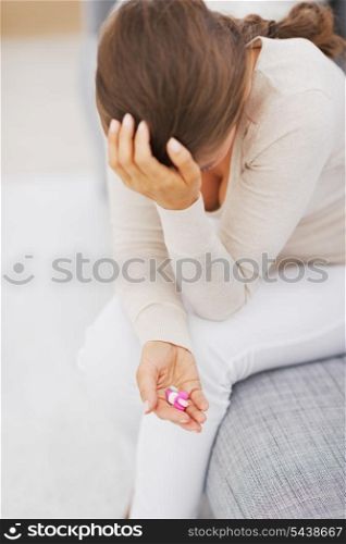 Closeup on pills in hand of stressed young woman