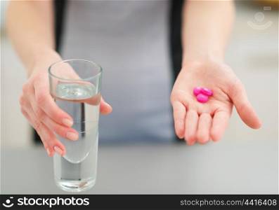 Closeup on pills in hand of young housewife