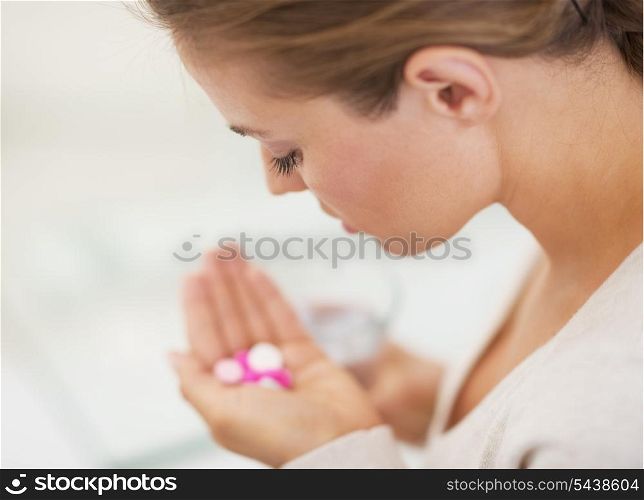 Closeup on pills in hand of young woman