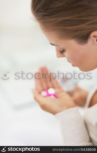 Closeup on pills in hand of young woman