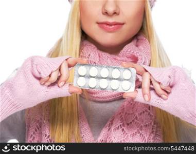 Closeup on pills pack in hand of teenager girl in winter gloves and scarf