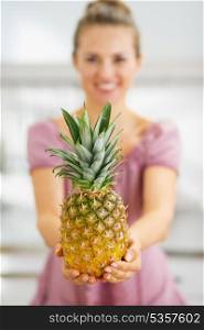 Closeup on pineapple in hand of housewife