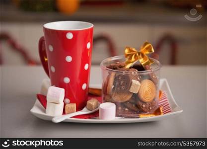 Closeup on plate with christmas cookies and cup of hot chocolate with marshmallow