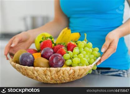 Closeup on plate with fruits in hand of young woman