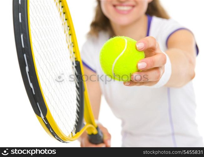 Closeup on racket and ball in hand of tennis player ready to serve