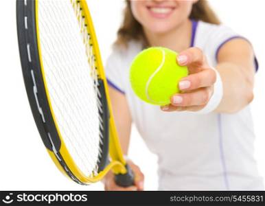 Closeup on racket and ball in hand of tennis player ready to serve