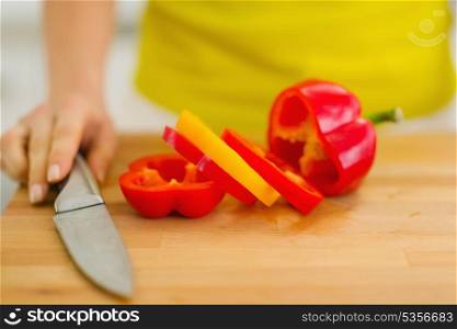 Closeup on red bell pepper with yellow slice on cutting board