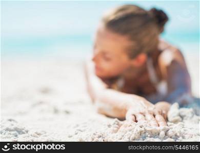 Closeup on relaxed young woman in swimsuit laying on sandy beach