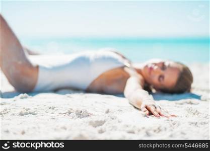 Closeup on relaxed young woman in swimsuit sunbathing on sandy beach