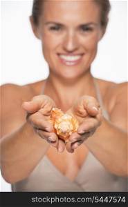 Closeup on sea shell in hands of smiling woman