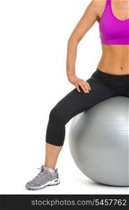 Closeup on slim young woman sitting on fitness ball