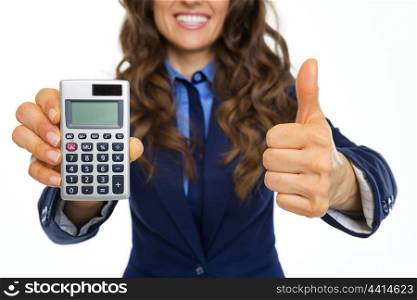 Closeup on smiling business woman showing calculator and thumbs up