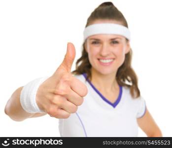 Closeup on smiling female tennis player showing thumbs up