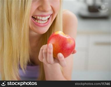 Closeup on smiling teenager girl eating apple