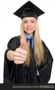 Closeup on smiling young woman in graduation gown showing thumbs up