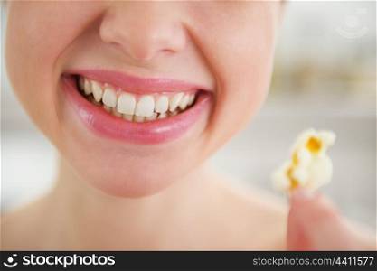 Closeup on smiling young woman with popcorn