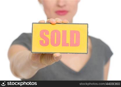 Closeup on sold sign holding by female. HQ photo. Not oversharpened. Not oversaturated. Closeup on sold sign holding by female isolated
