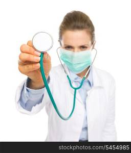 Closeup on stethoscope in hand of doctor woman in mask