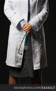 Closeup on stethoscope in hand of doctor woman isolated on black