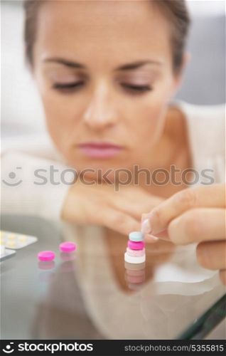 Closeup on stressed young woman playing with pills
