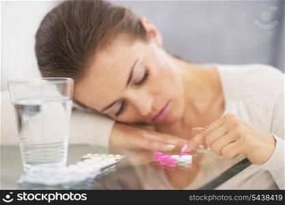 Closeup on stressed young woman playing with pills