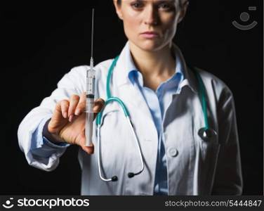 Closeup on syringe in hand of doctor woman isolated on black