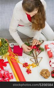 Closeup on table where female making Christmas decorations. Upper view