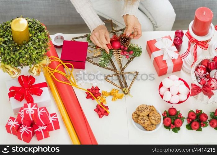 Closeup on table where woman making Christmas decorations. Upper view