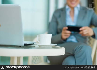 Closeup on table with laptop and business woman in background