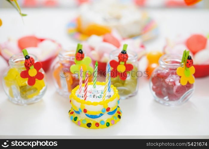 Closeup on table with sweets and birthday candle cake