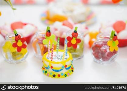 Closeup on table with sweets and birthday candle cake