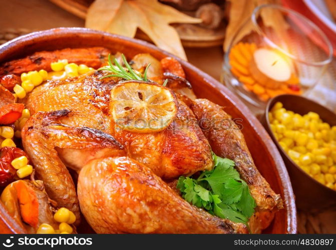 Closeup on tasty roasted chicken with vegetables on the table, traditional food of Thanksgiving day, autumnal holiday concept