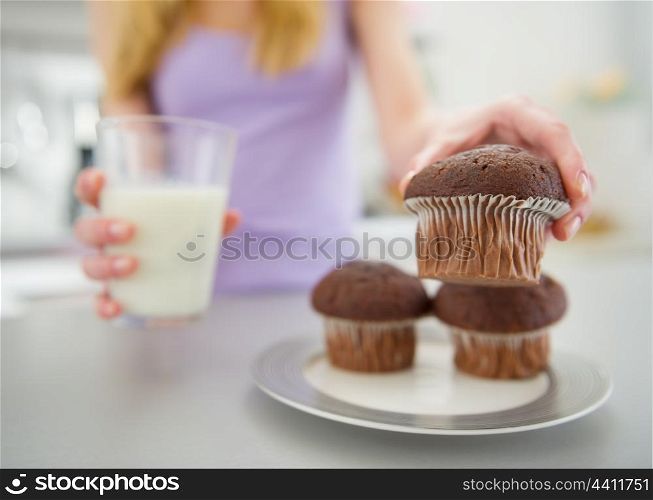 Closeup on teenager girl with milk taking chocolate muffin
