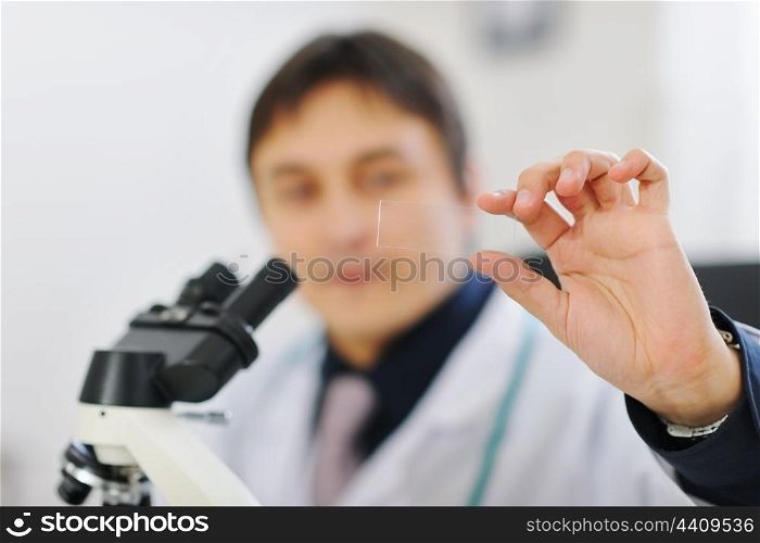 Closeup on test sample in hand of male researcher