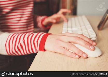 Closeup on the hand of a young woman as she is using a computer mouse