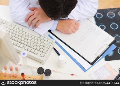 Closeup on tired medical doctor sleeping on table