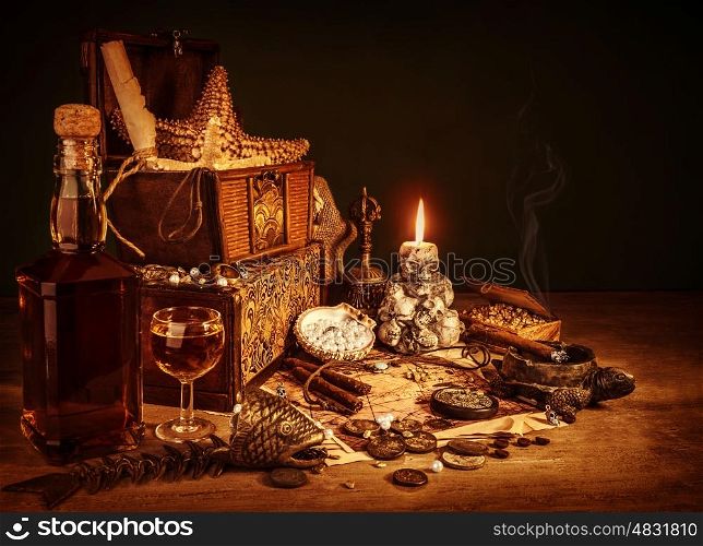 Closeup on treasure still life, luxury vintage accessories, pirates booty, bottle with rum, fish skeleton, cigars and golden coins, dangerous adventure concept