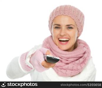 Closeup on TV remote control in hand of happy woman in knit winter clothing