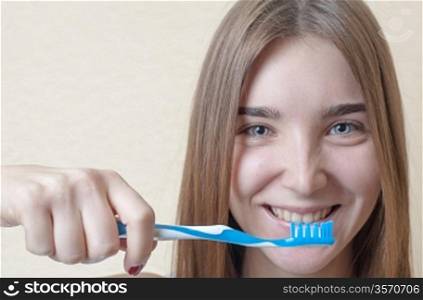 Closeup on woman&acute;s toothy smile brushing her teeth