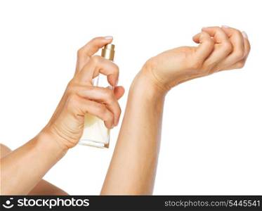 Closeup on woman applying perfume on hand