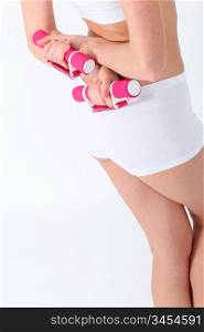 Closeup on woman body lifting weights