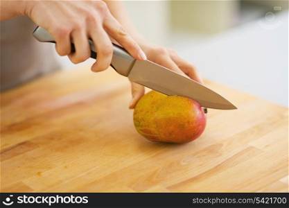 Closeup on woman cutting mango