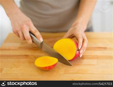 Closeup on woman cutting mango