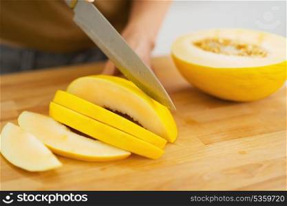 Closeup on woman cutting melon on slices