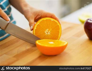 Closeup on woman cutting orange