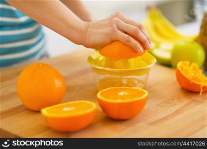 Closeup on woman making orange juice
