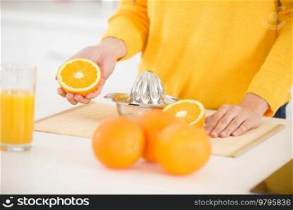 closeup on woman making orange juice