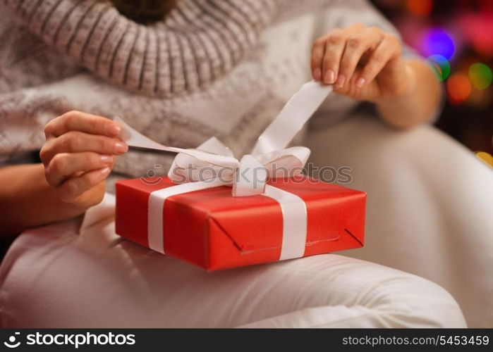 Closeup on woman opening Christmas present box